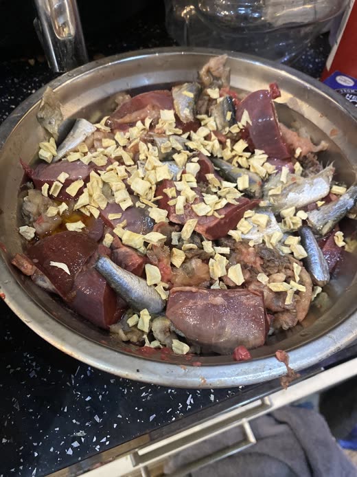 Close-up bowl of raw liver, heart and bone topped with chopped vegetables